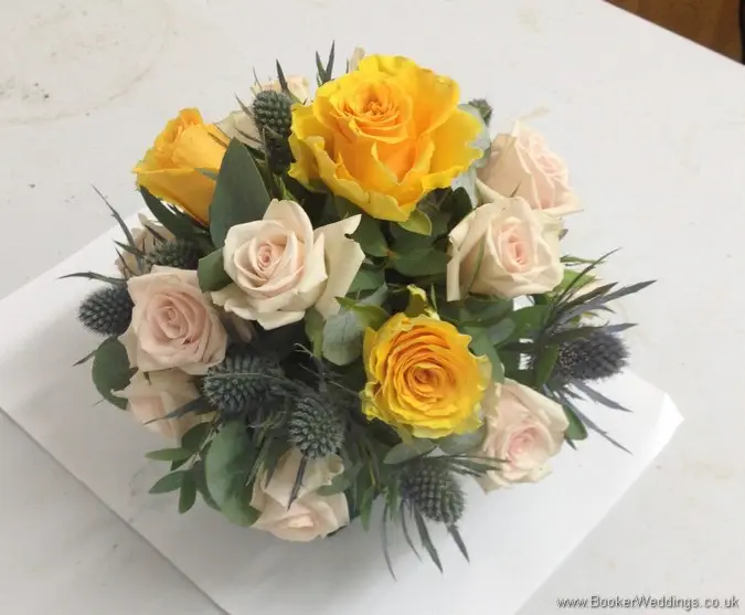 Gold, peach and Navy Cake Flower Decoration with Roses, Spray roses, Eryngium, Brunia Berries and Eucalyptus Side View