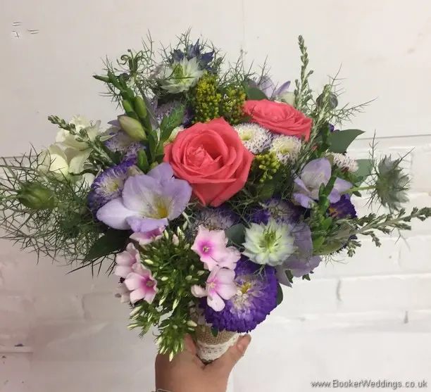 Bright and wild just picked bridesmaid bouquet with Aster, Silver Foliage’s, Nigella, Coral Roses, White spray roses, Solidaster, Purple Freesia, Pink Phlox