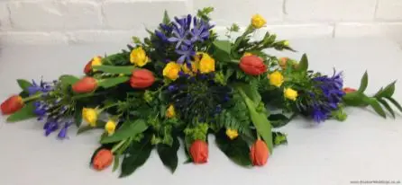 Brightly Coloured Low and Long Top Table Arrangement with Tulips, Agapanthus and Spray Roses