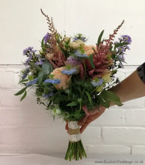 Wild Garden Hand Tied Bridal Bouquet in Peach, purples and blues with roses, spray roses, astilbe, lissianthus, nigella, september flower and daisies Side View