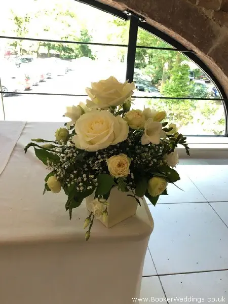 Registrar Table Arrangement of Roses Freesia Spray Roses and Gypsy Grass