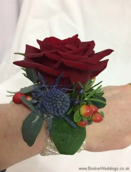Best woman christmas wedding wrist corsage with a red rose, eryngium, winter berries and greenery_side