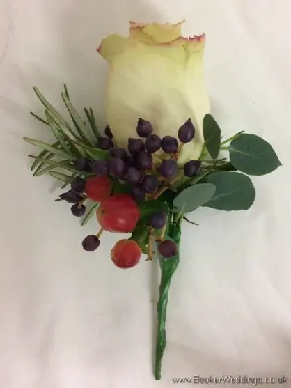 Winter Buttonholes for men with sandy roses, greenery and berries