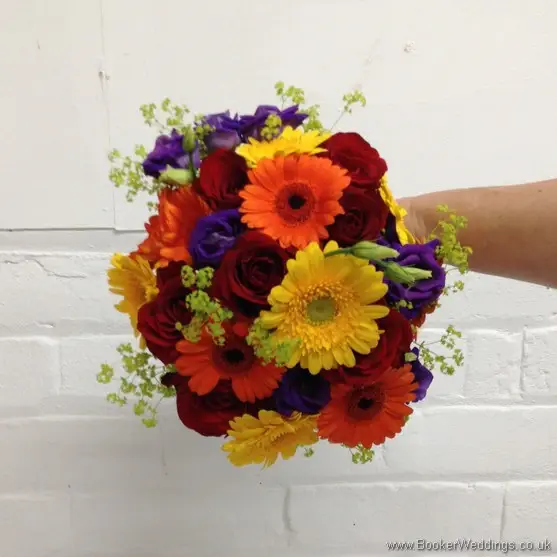 Bright and vibrant bridal hand-tied bouquet featuring roses, gerberas, lissianthus and alchamelia molis