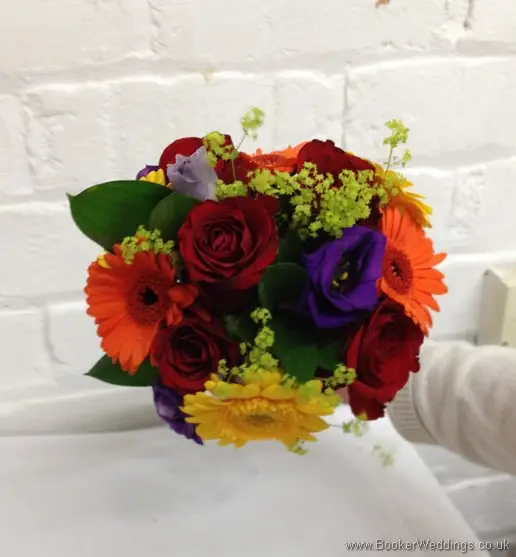 Bright and vibrant hand-tied bridesmaid bouquet featuring roses, gerberas, lissianthus and alchamelia molis