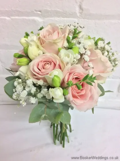 Soft pink and white bridesmaid hand tied bouquet with roses, freesia and gypsy grass tilted view