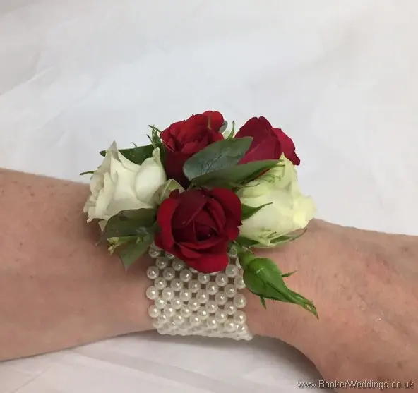 Mothers wrist corsage of white and red spray roses side view
