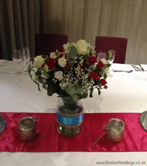 Top table jar decorations of red and white roses, spray roses, lissianthus and gypsophila at Hard Days Night Hotel Liverpool