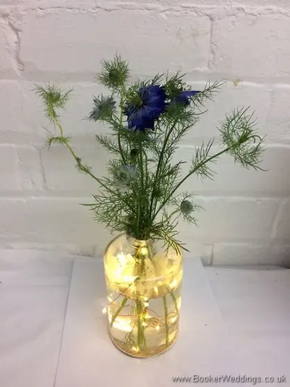 Nigella in a lit up bottle for table decorations at reception