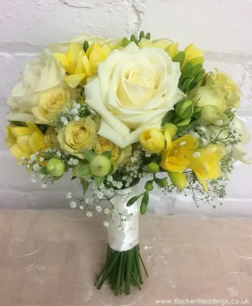 Bride bouquet of white roses, yellow freesia, spray roses and gypsophila and ribbon handle