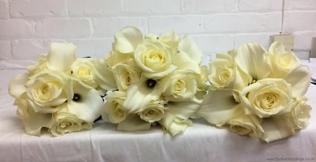 Hand tied bridal and bridesmaid ivory roses and calla lilies bouquets with royal blue ruffle ribbon_side view