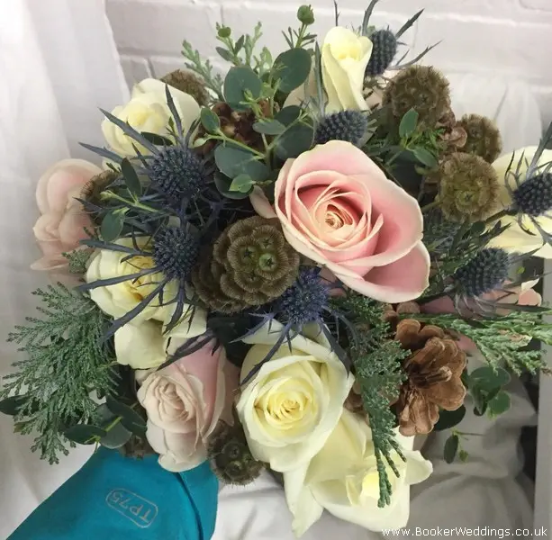 Natural rustic style Christmas Wedding bride bouquet of blush and ivory roses, eryngium, scabisoa, pine cones, eucalyptus and spruce