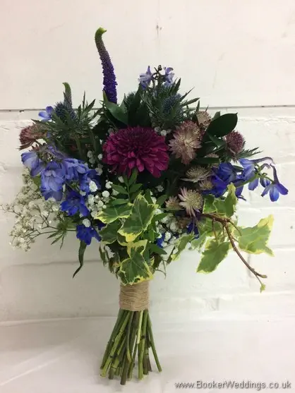 Blue & purple wild, rustic, country style bridal bouquet with delphinium, crysanthemum blooms, eryngium, astrantia, veronica, gypsophila and ivy side view