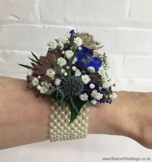 Blue and purple wild and rustic wrist corsage with eryngium, astrantia, veronica and gypsophila side view