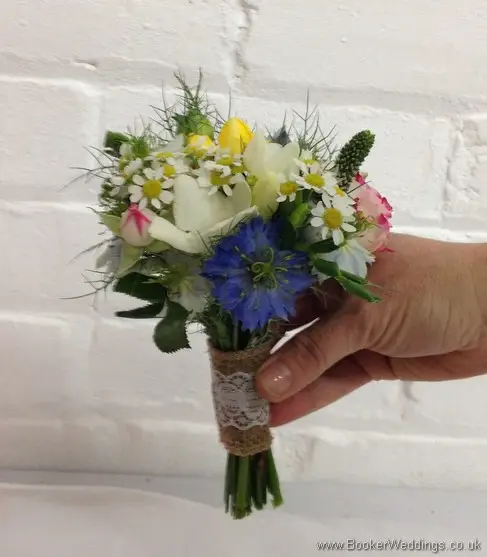 Mini just picked country style Flowergirl Hand Tied bouquet with Tanacetum, spray roses, freesia and nigela side view