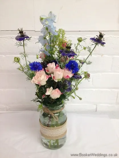 Table decorations in a just picked country style with Cornflower, spray rose, nigela, delphinium