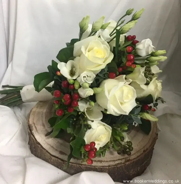 Christmas wedding bride bouquet of ivory roses freesia lissianthus red hypericum berries and eucalyptus
