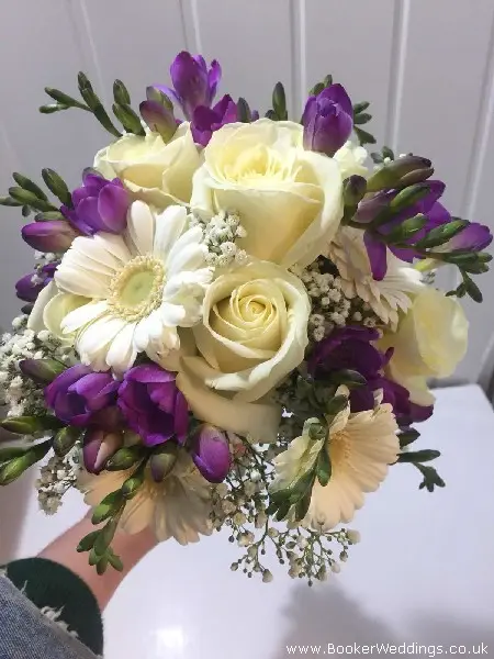 white and purple bride handtied bouquet with roses gerberas freesia and gypsy grass