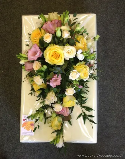 Peach, pink and yellow flowers with roses, spray roses, freesia, bouvarida and lissianthus in a tear drop hand tied bridal bouquet