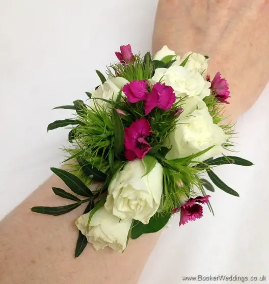 Bridesmaid Wrist Corsage featuring Spray Roses, Freesia and Sweet William on a pearl bracelet showing on wrist