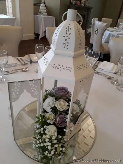 White lantern table arrangement with cream and lilac roses and gypsophila at 30 James Street
