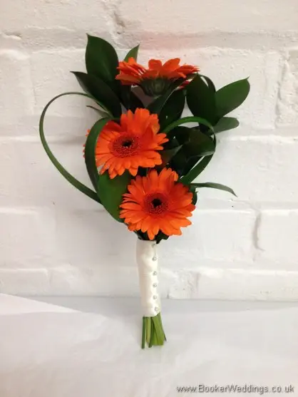Flower girl handtied bouquet with orange gerberas and greenery side view