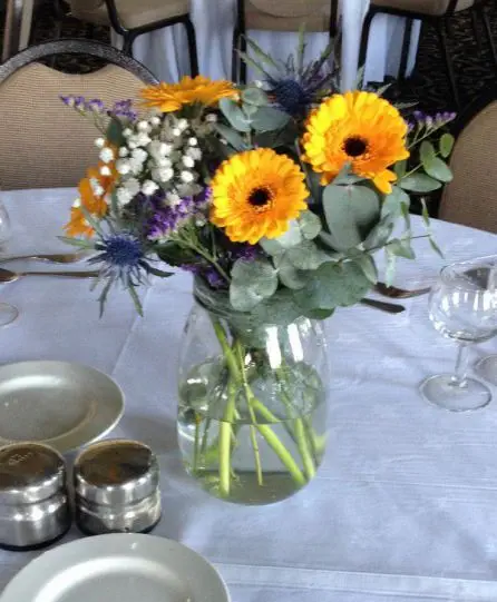 Yellow and Blue Jar Table Arrangement Gerbera Craspedia Eryngium and Gypsophilia