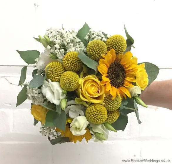 Bridesmaid handtied bouquet in yellow and creams with yellow sunflowers, craspedia, roses, gypsy grass, lissanthus and grey eucalyptus