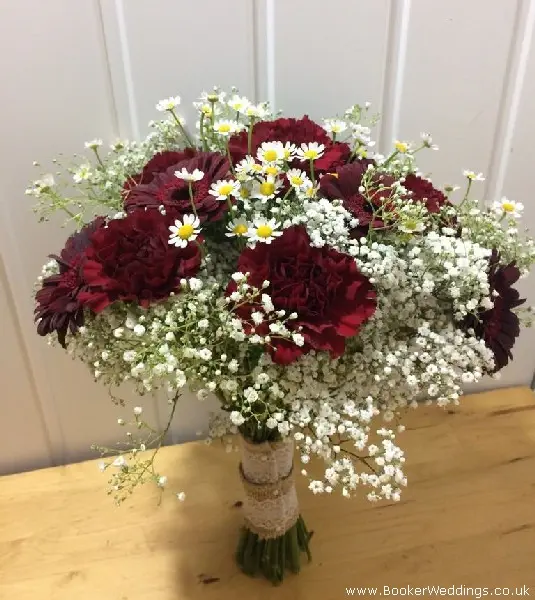 bride handtied bouquet burgandy gerbera carnations tanacetum daisys and gypsophila tied with hessian and lace